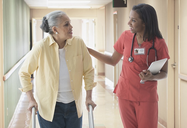 Older patient talking with nurse in hospital