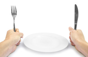 Plug and knife in hands on white background with plate