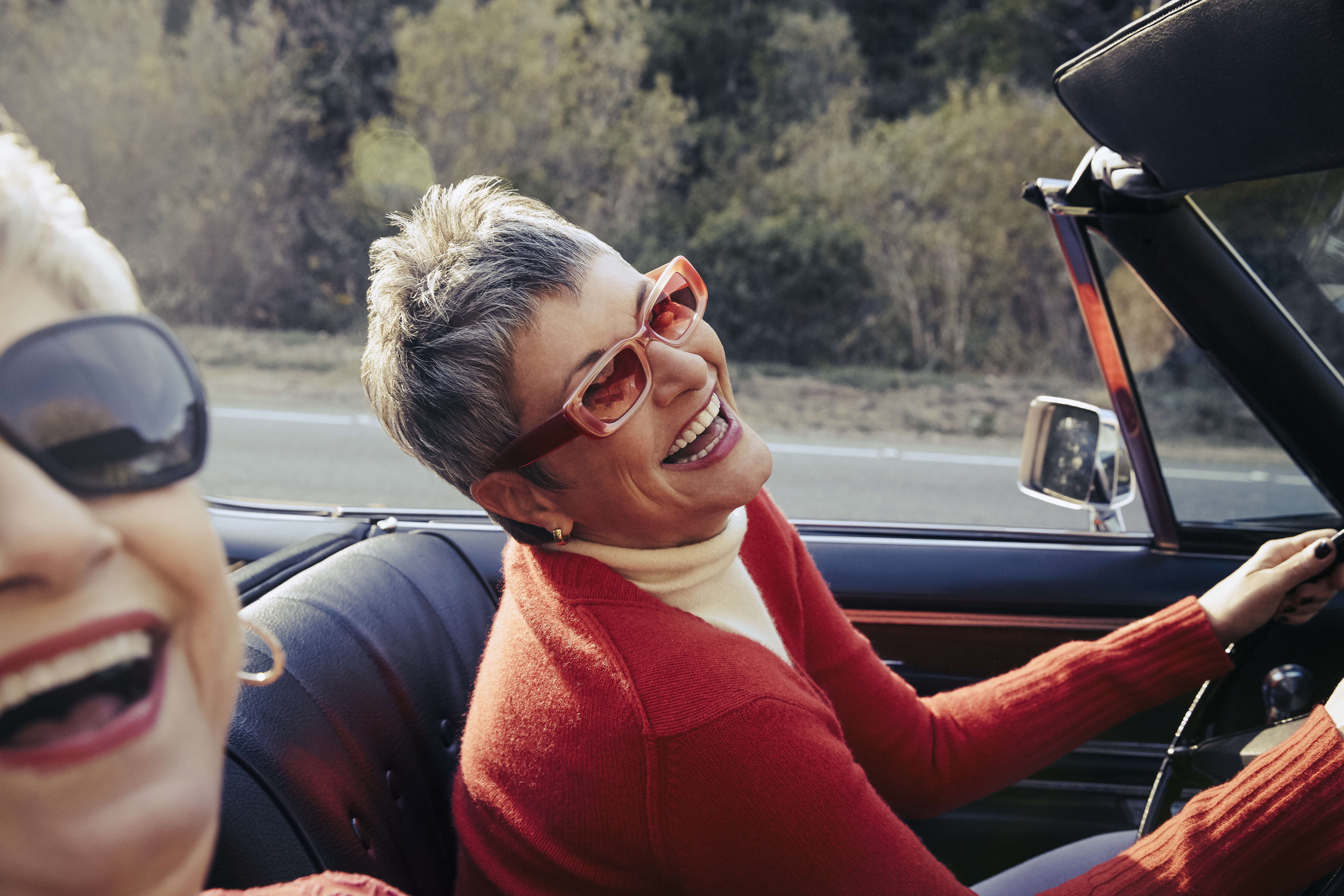 Happy mature women driving in convertible car