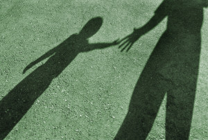 Shadows of adult giving helping hand to child