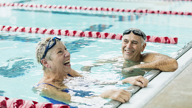 A man and woman hanging on the wall inside an indoor pool