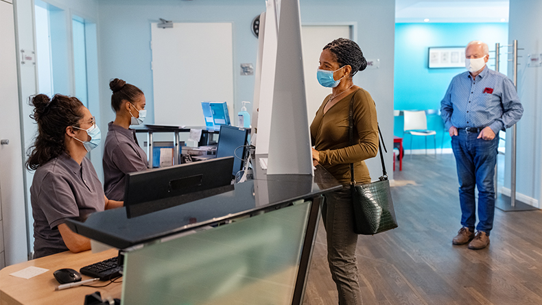 Woman speaking to receptionist at medical office