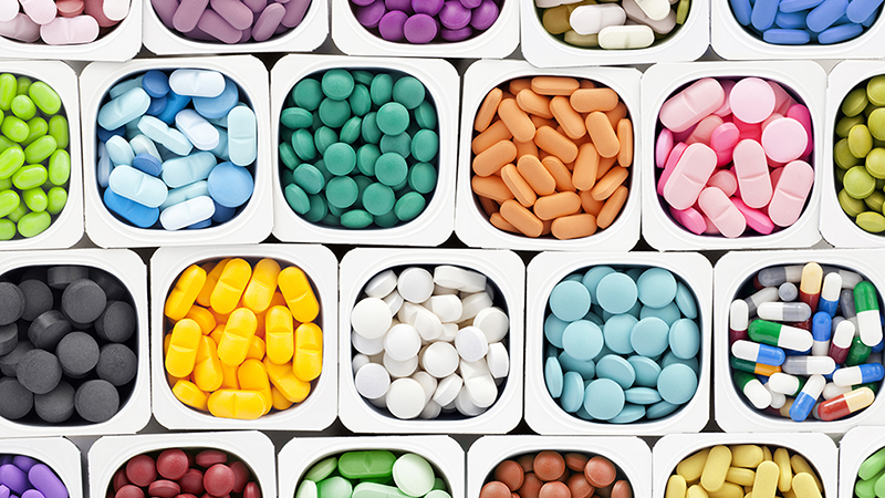 A variety of multicolored brain health supplement pills inside plastic containers