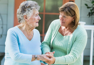 Caregiver helping senior woman on a walk