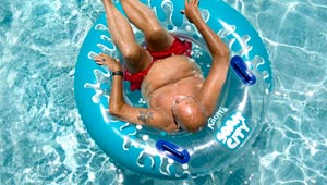 Man lounges in a pool. Heat wave can be dangerous for boomers and seniors