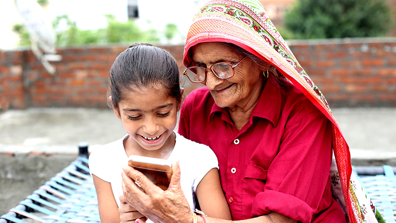 Grandmother and granddaughter look at a smartphone