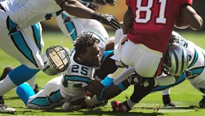 A professional football player loses his helmet during a play on the field