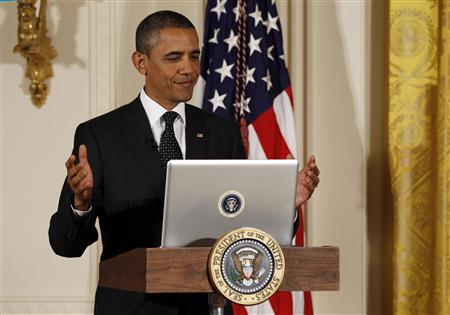 U.S. President Barack Obama reacts after tweeting at his first ever Twitter Town Hall in the East Room at the White House in Washington