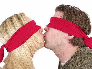 Woman and man kissing blindfolded