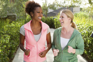 Two women jogging outside on a sunny day