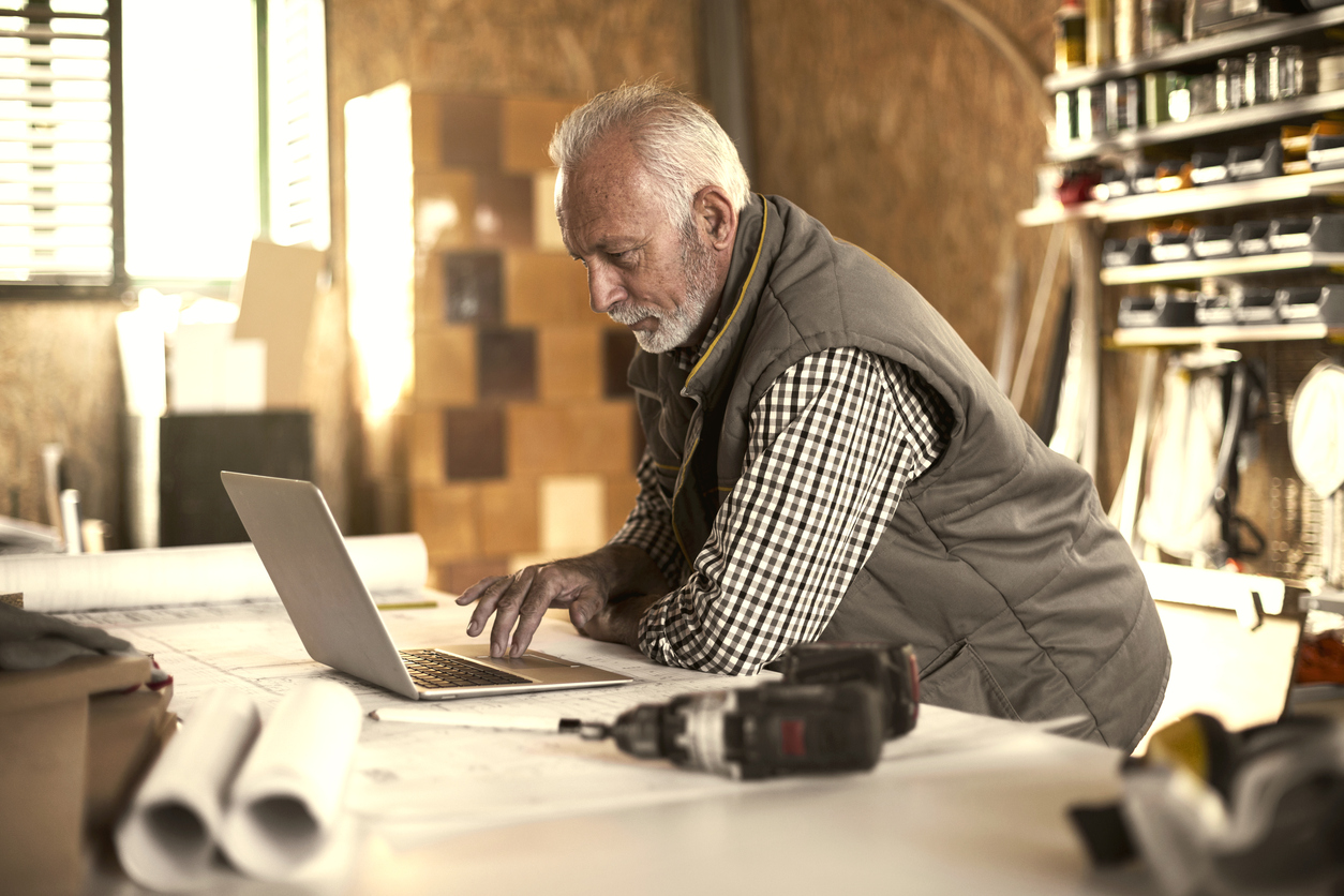 Mature designer looking at laptop