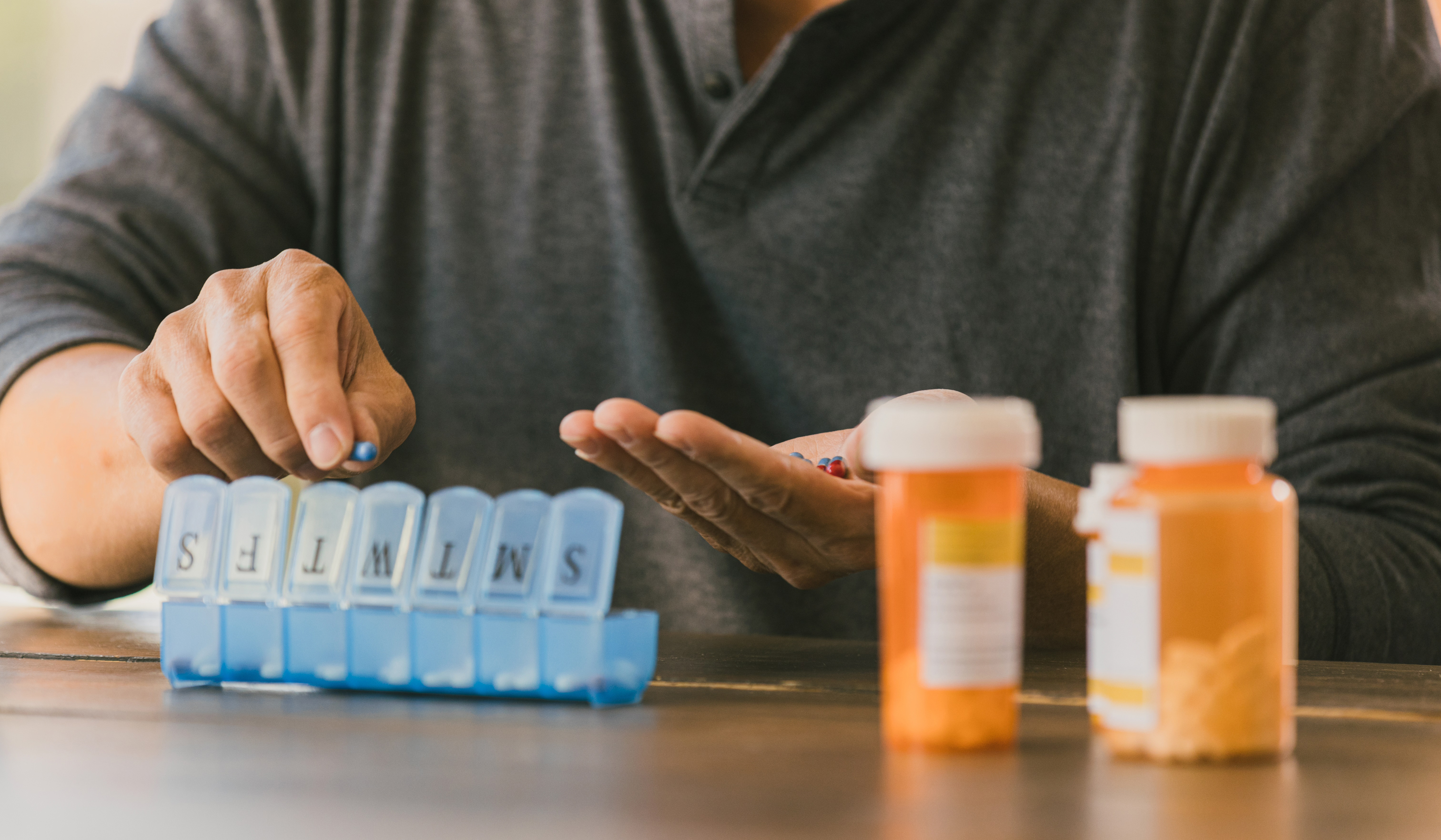 adult organizes prescription medication 