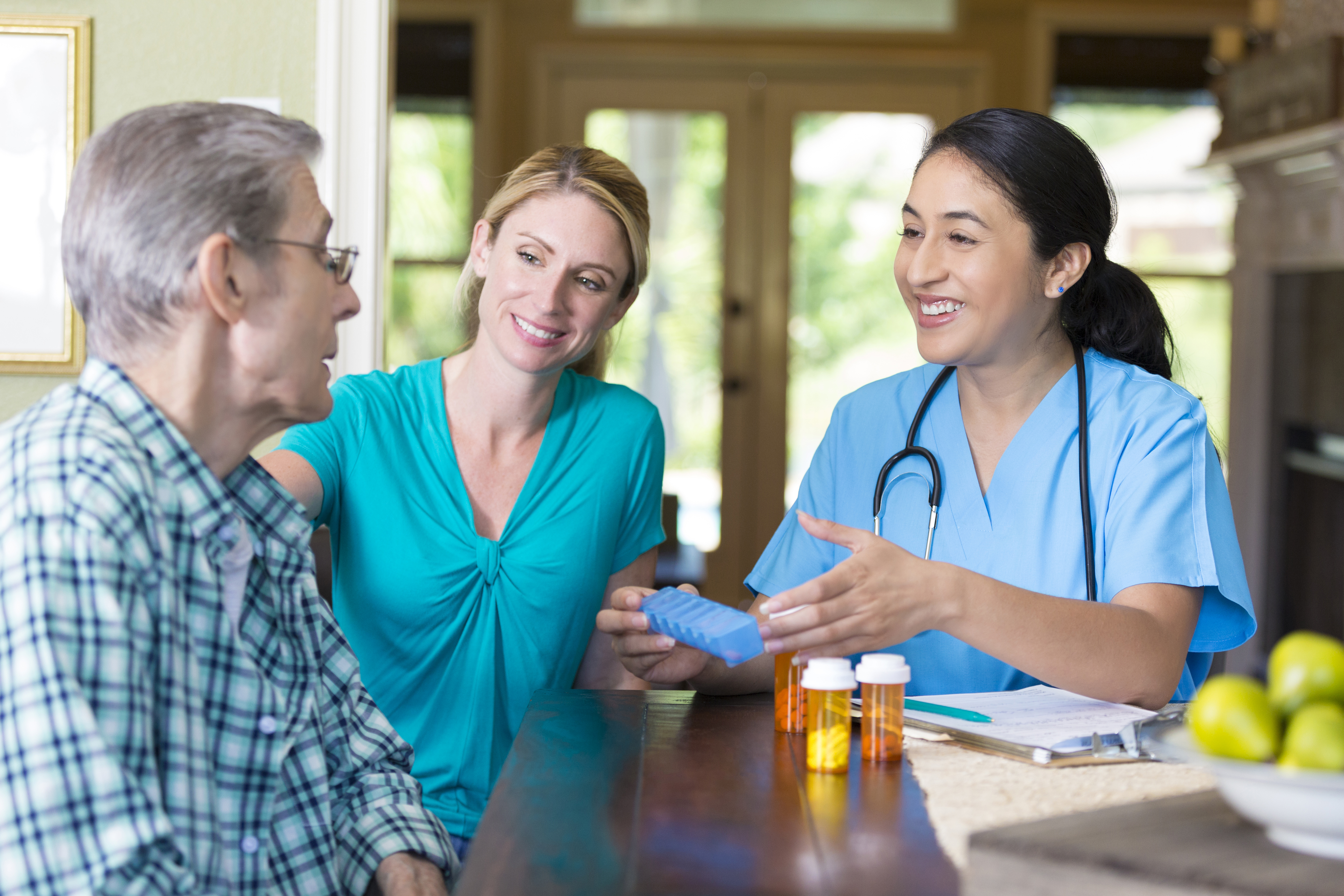 Home healthcare nurse helps senior patient organize medication