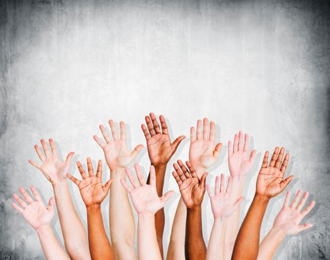 Group of Human Arms Raised with Concrete wall