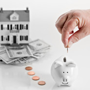 Piggy bank with trail of pennies leading to a house