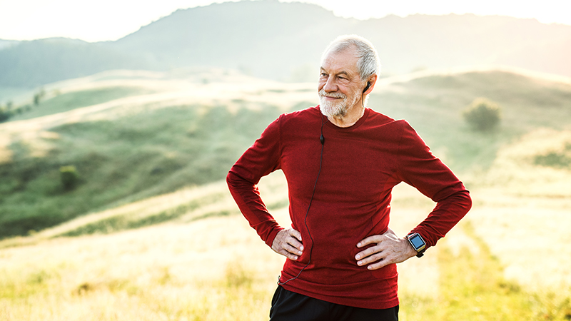 An active man with earphones outdoors in nature