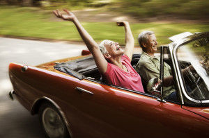 Couple driving in red convertible