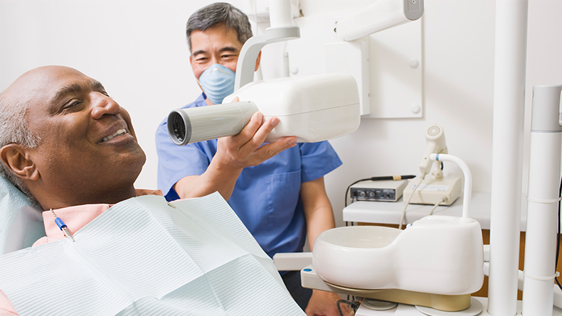 Dentist takes x-rays of patient's mouth