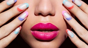 Close up of woman's colorful manicure and pink lipstick