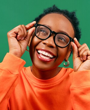 Woman smiling with eye glasses with on a bright green background
