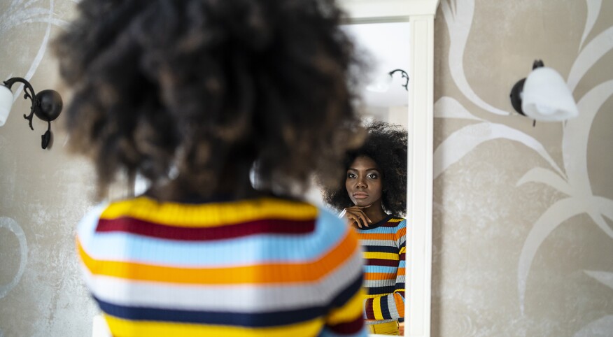 image_of_woman_looking_in_mirror_contemplative_GettyImages-1135286715_1800