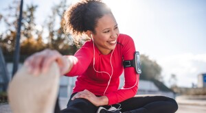 Woman stretching after a workout listening to her smartphone