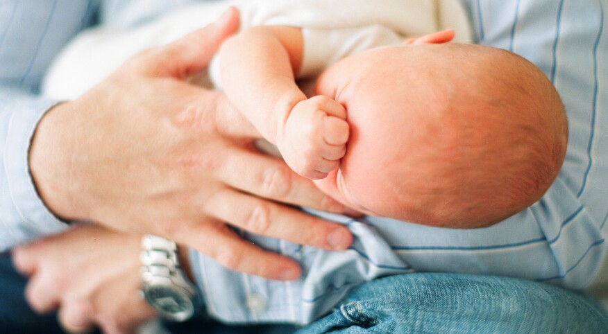 Close Up Of A Father Holding His Newborn Baby Girl