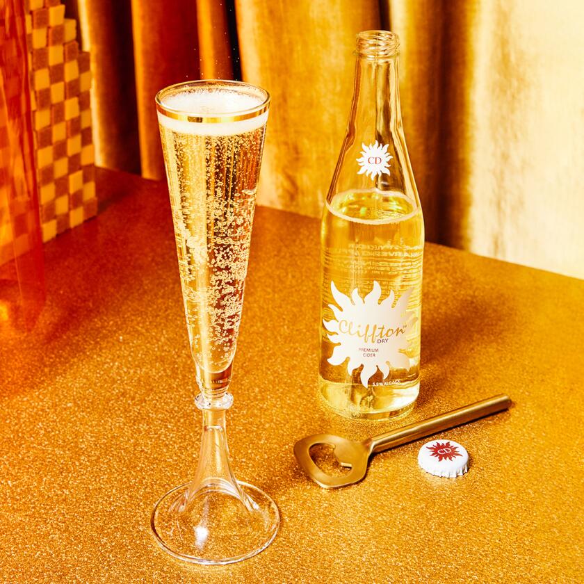 Product shot of low calorie alcohol in front of gold curtain