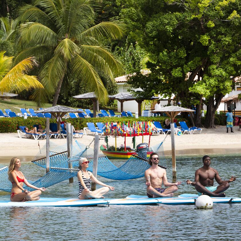 Four hotel guests doing yoga on paddle-boards