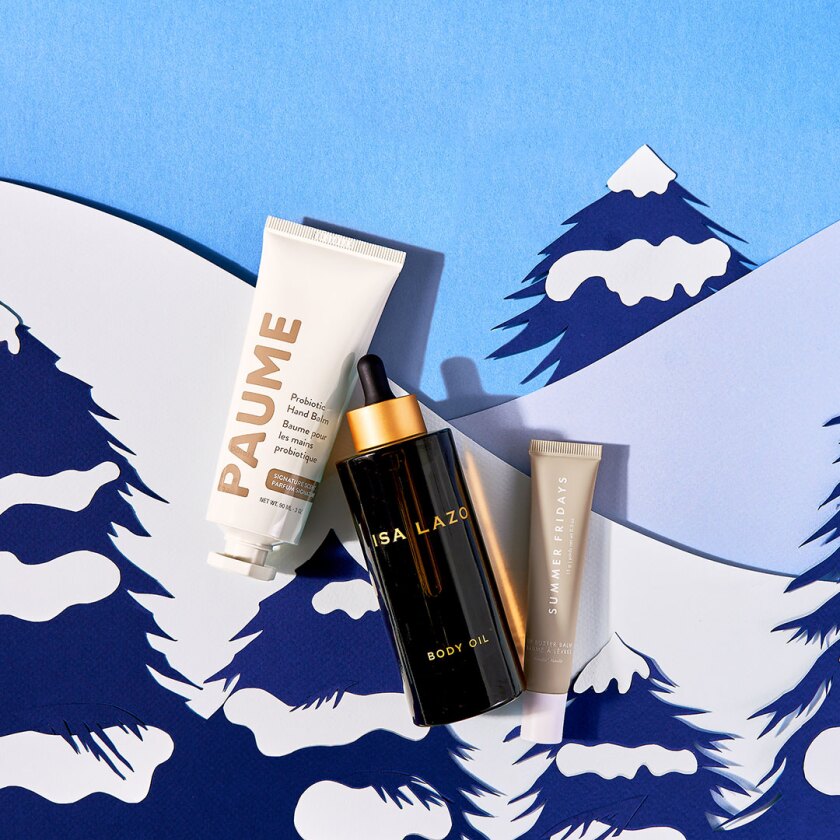 Beauty skincare products styled within cut paper winter scene