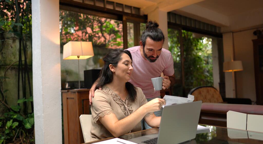 Woman and adult son looking over documents at home
