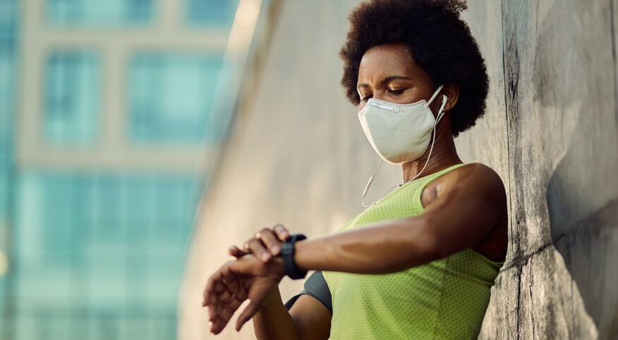 image_of_woman_wearing_mask_and_checking_watch_GettyImages-1256557417_1800.jpg