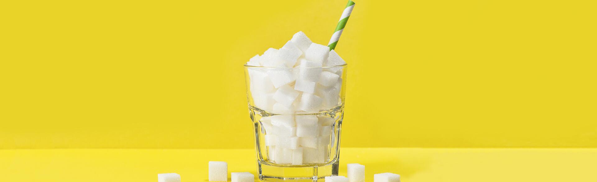 cup filled with sugar cubes with straw in it