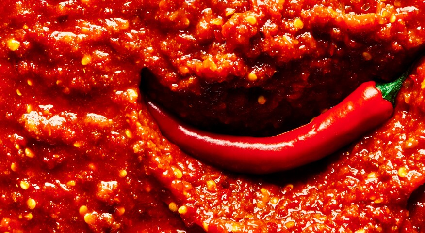 An image of a chili pepper in hot sauce.