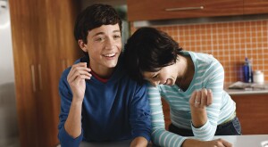 Mother and her teenage son laughing in their kitchen
