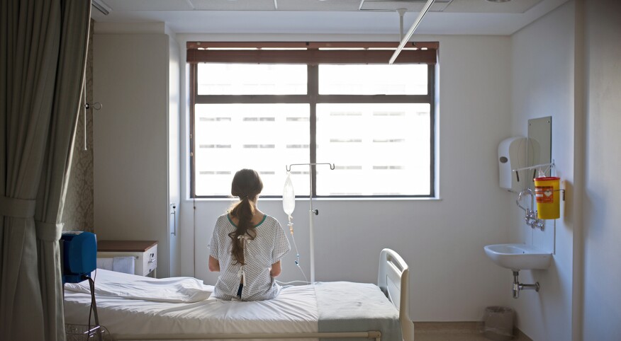 Patient sitting on hospital bed waiting