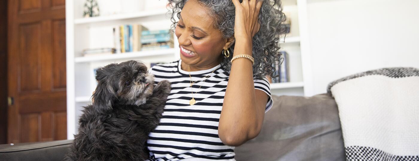 Black Woman Cuddles with her dog at home