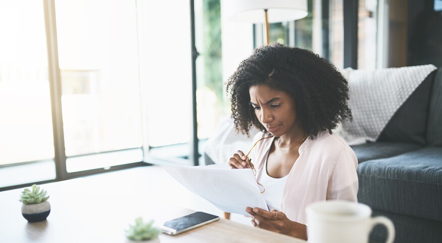 Woman sitting at table looking over finances