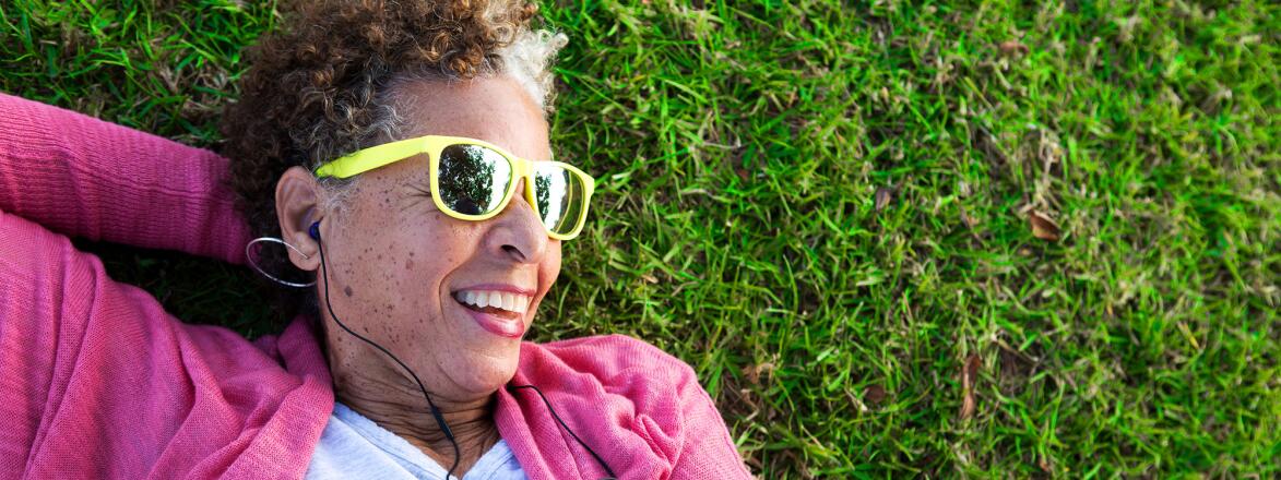Woman lying on grass wearing sunglasses