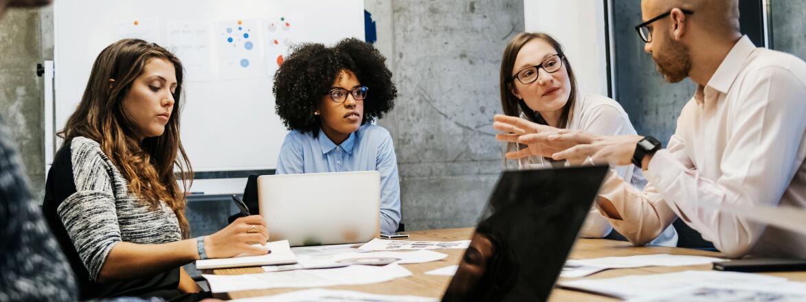 Women in meeting being talked over by a man using hand gestures