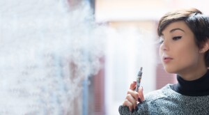 close up of a young woman smoking a vape pen