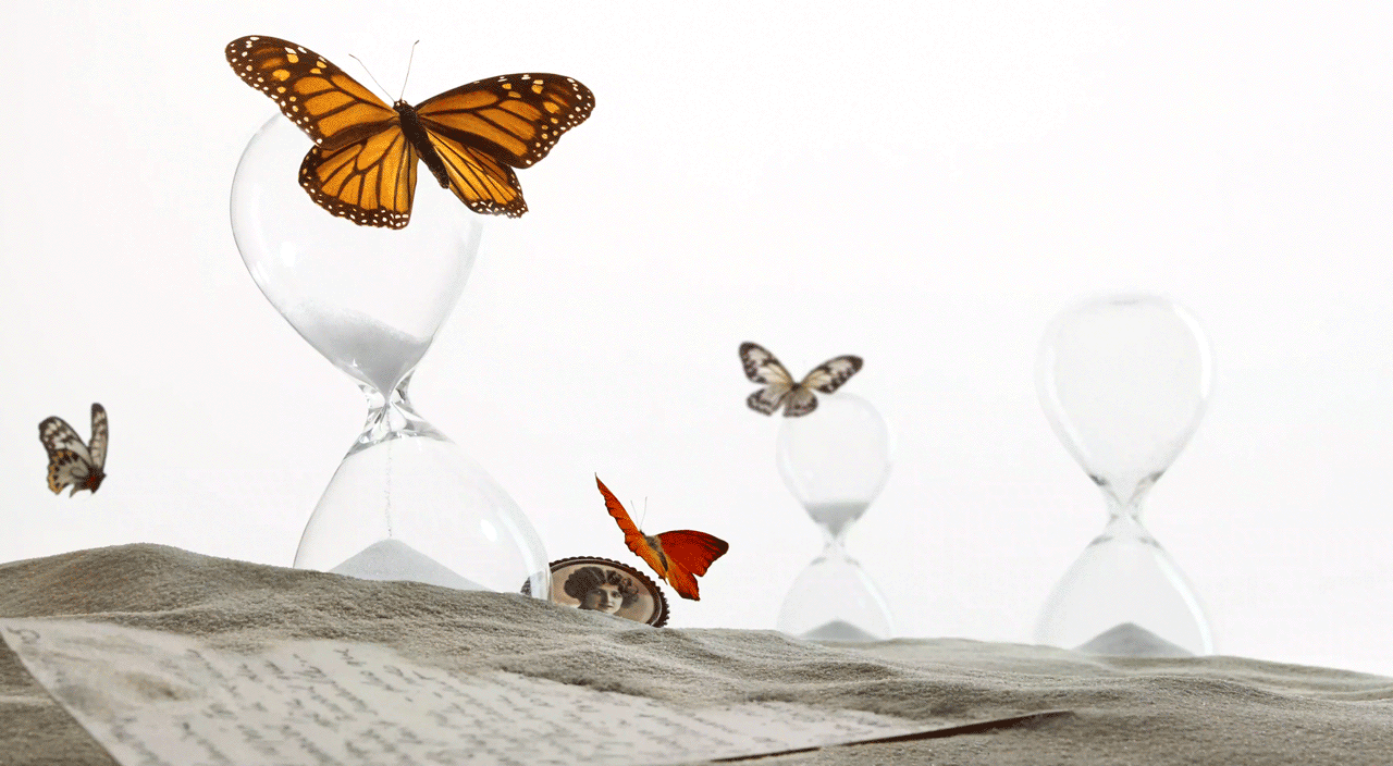 Butterflies on hour glasses in pile of sand
