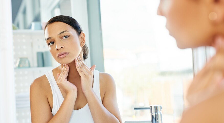 image_of_woman_checking_face_in_mirror_GettyImages-1157106302_1800