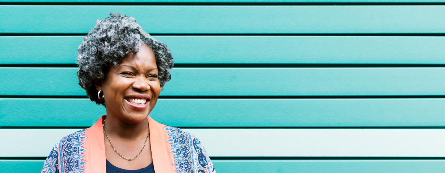 Woman smiling in front of a turquoise wall