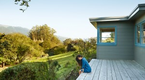 Woman sitting alone on her back porch surrounded by nature