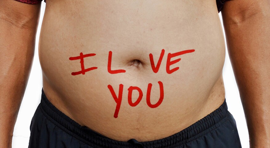Shirtless man showing large belly with the words I LOVE YOU written on it