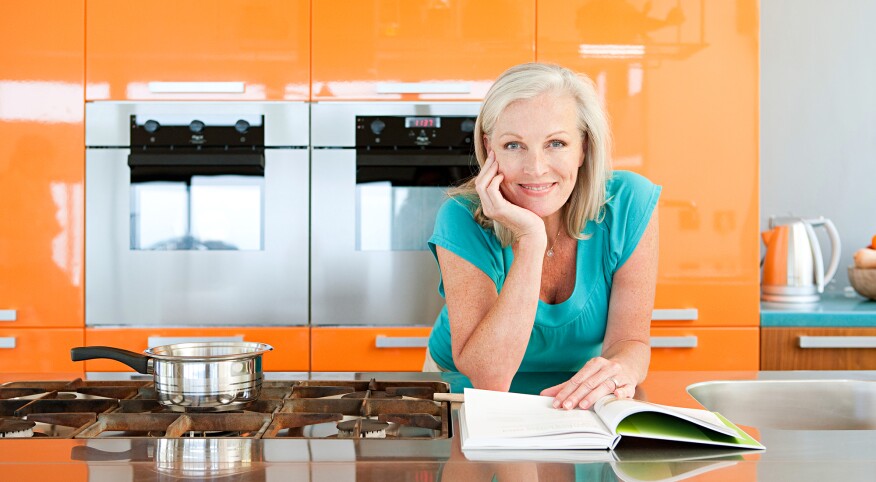 Woman in kitchen with recipe book
