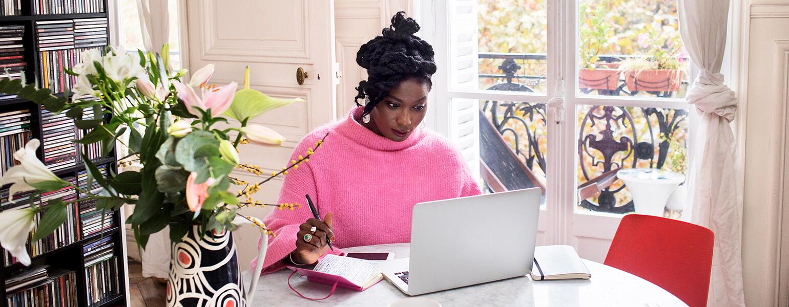 image_of_black_woman_sitting_at_table_working_on_laptop_GettyImages-1063295912_1540.jpg