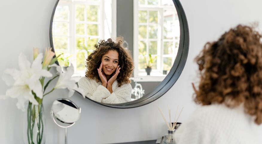 image_of_woman_happily_looking_in_mirror_GettyImages-1282976099_1800