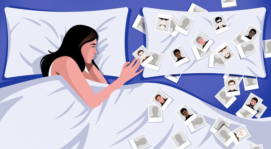 Woman lying in bed looking at photos of men